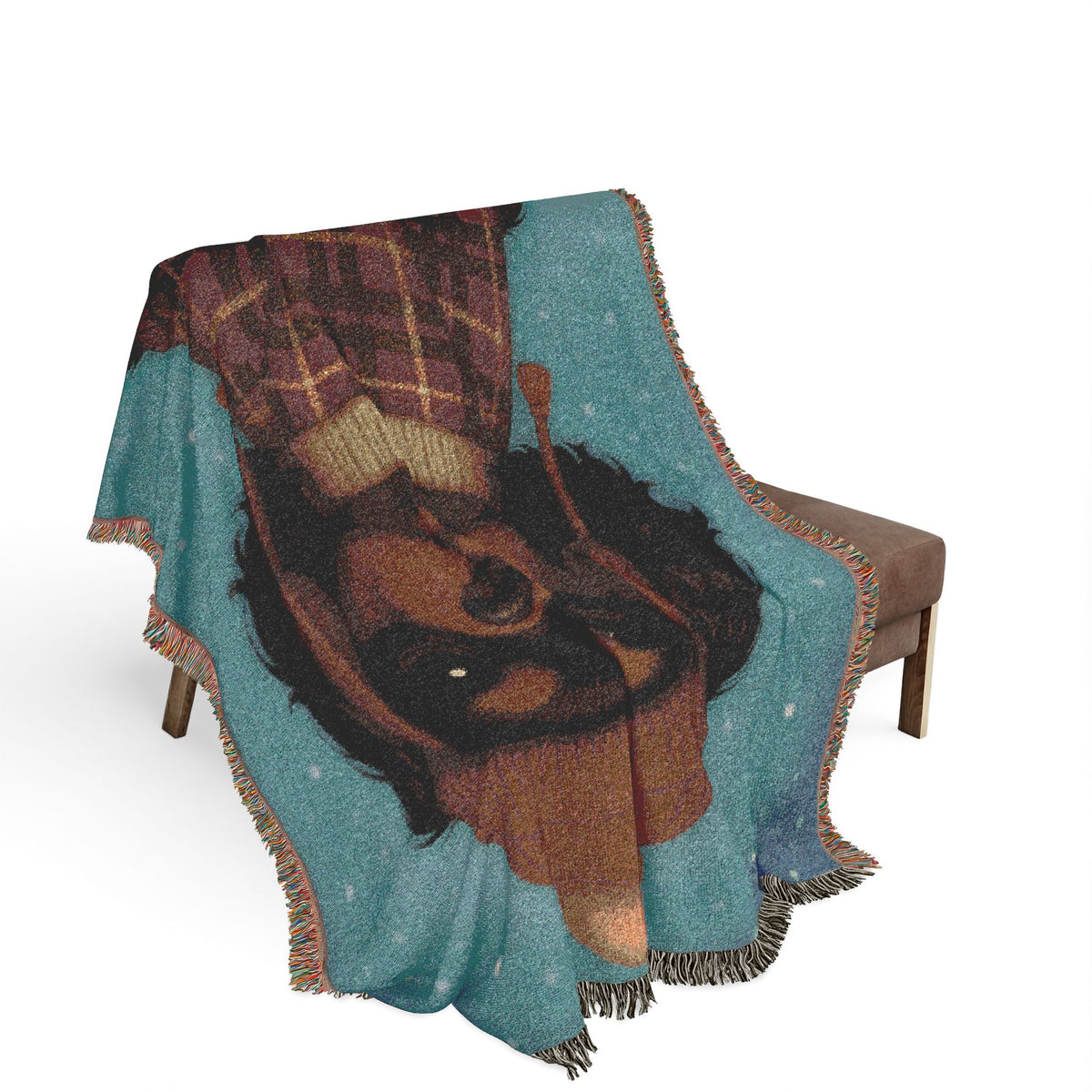 Black and Tan Cavalier woven cotton blanket draped over a brown armchair, close view of the design and fringe